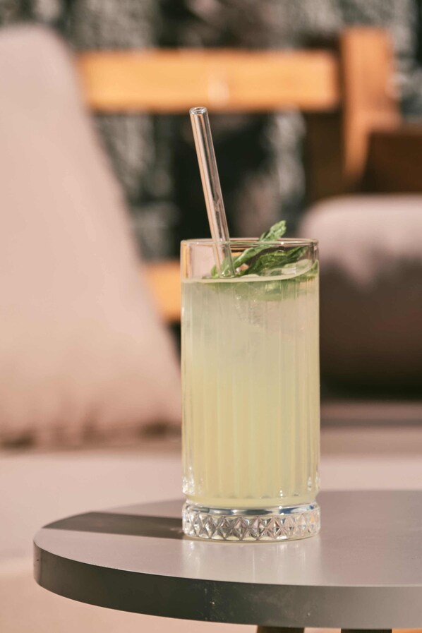 A clear glass with a straw on a round table.