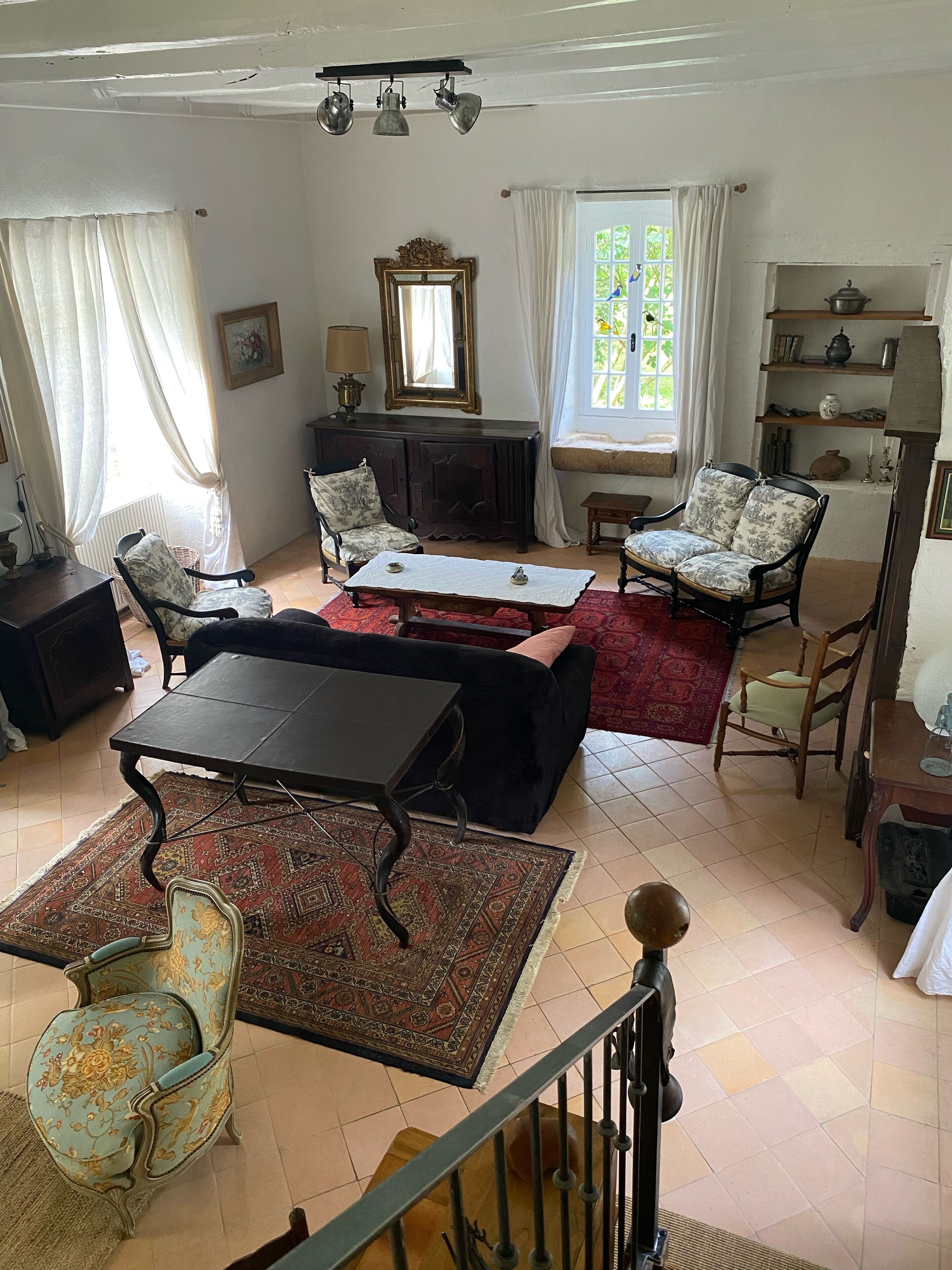 A traditional living room with a sofa set, a dining table, and a fireplace.