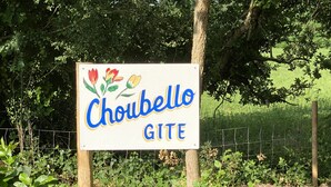 En skylt med namnet ”Chouabello GITE”, omgiven av grönska.