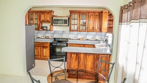 Uma cozinha compacta com armários de madeira, micro-ondas, fogão e pia.