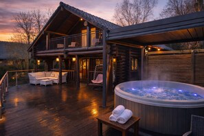 A log cabin with a hot tub, outdoor seating, and a covered deck. - Nightingale Lodge, 2 Storey Scandinavian style lodge, Sleeps 8, Hot tub, Huge fishing deck (Tattershall)
