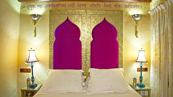 A room with a bed, two nightstands, and a decorative wall with a golden pattern and two purple arch-shaped panels.
