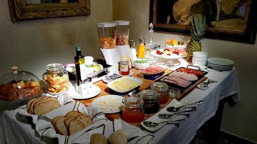 Un buffet de petit-déjeuner proposant une variété d’aliments, notamment du pain, des viennoiseries, des fruits et des boissons.