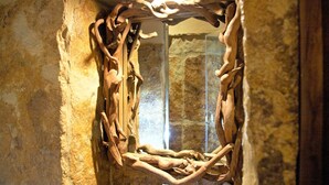 A room with a stone wall and a wooden sculpture. - Casa pinto (Reguengos de Monsaraz)