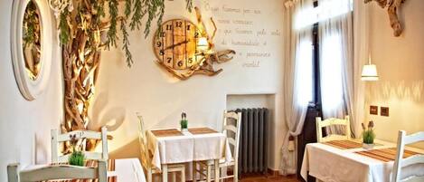 A cozy dining area with rustic decor, including a wall clock and a fireplace.
