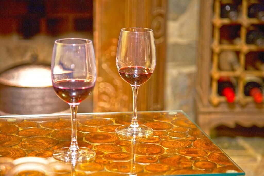 Dos copas de vino sobre una mesa con superficie estampada.
