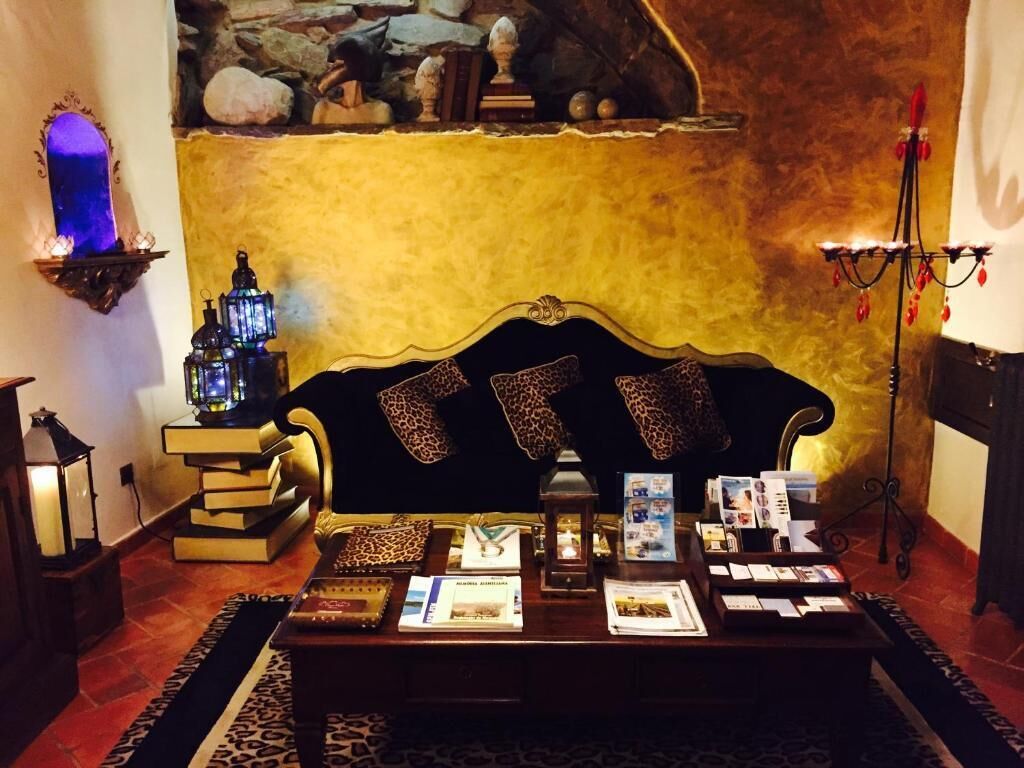 A cozy reading area with a sofa, books, and a decorative lamp.