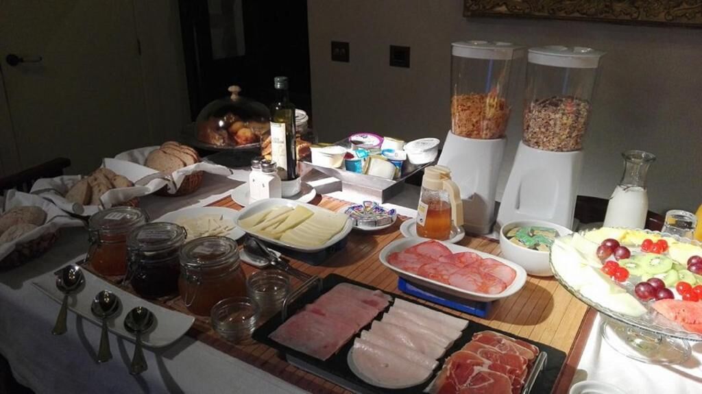 A buffet table with various food items including meats, cheeses, fruits, and condiments.