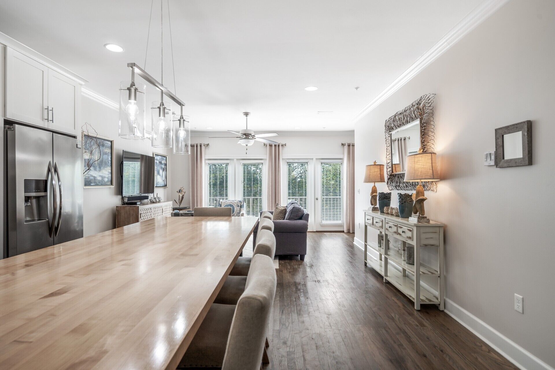 A spacious kitchen with a long island, modern appliances, and pendant lighting.