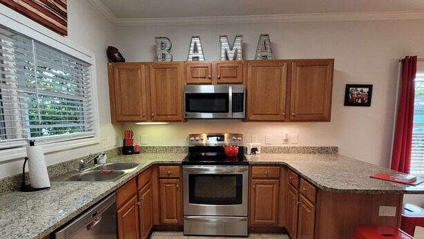 A kitchen with wooden cabinets, stainless steel appliances, a granite countertop, and a window with blinds. - Walk to Stadium/Strip/Downtown! 2 bd/2 bath, Off-street parking! (Tuscaloosa)