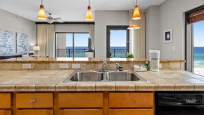 Una cocina moderna con una isla grande, pileta doble e iluminación colgante.