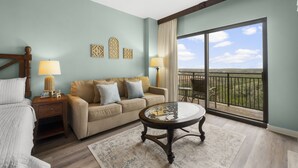 A hotel room with a large balcony, a sofa, a round coffee table, and a bed. - Origin 0915 - Studio King - Cozy Nature View (Panama City Beach)