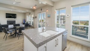Une cuisine moderne dotée d’un grand îlot central, d’un coin repas et d’un balcon avec vue.