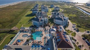 Un complexe hôtelier comprenant plusieurs bâtiments, une piscine et offrant une vue sur la plage.