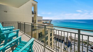 A balcony with turquoise Adirondack chairs overlooking a beach and ocean. - Origin 1604 -PENTHOUSE- 3 Bedroom- Private Large Sunset Deck (Panama City Beach)