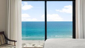 Una habitación con un amplio ventanal que da a una playa y al océano.