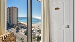 A view from a window with a door labeled "Captain's Quarters" and a view of a beach and high-rise buildings.