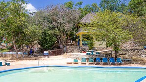 A swimming pool with blue chairs and a gazebo. - Haley's Paradise at Blue Hole (Little Bay)