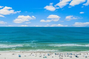 Een strand met helderblauw water en een zandstrand.