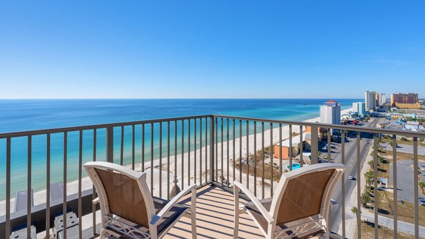A balcony with two chairs overlooking a beach and cityscape. - Origin 1602/1604- PENTHOUSE 6 Bedroom - One of a kind unit - TWO Large Decks (Panama City Beach)
