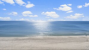 Ein Strand mit blauem Himmel und ruhiger See.