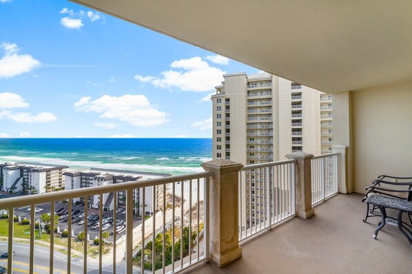 A balcony with a view of the ocean and a parking lot. - Grand Panama 1005 - Tower Two - 2 bedroom - Large Deck with Gulf Views (Panama City Beach)