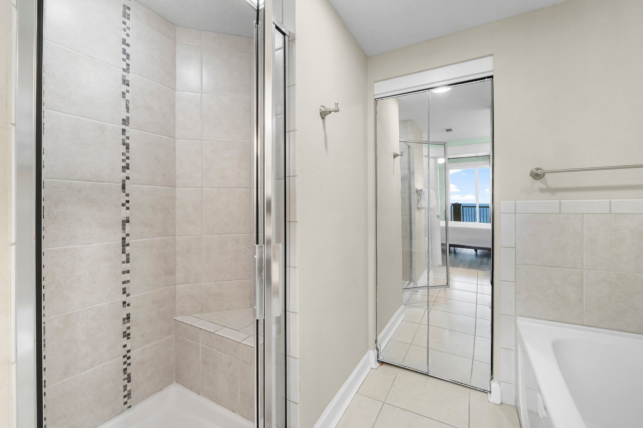 Une salle de bain moderne dotée d’une douche à parois de verre, d’une baignoire et d’une douche à l’italienne.