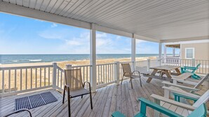 Une terrasse couverte offrant une vue sur la plage et l’océan.
