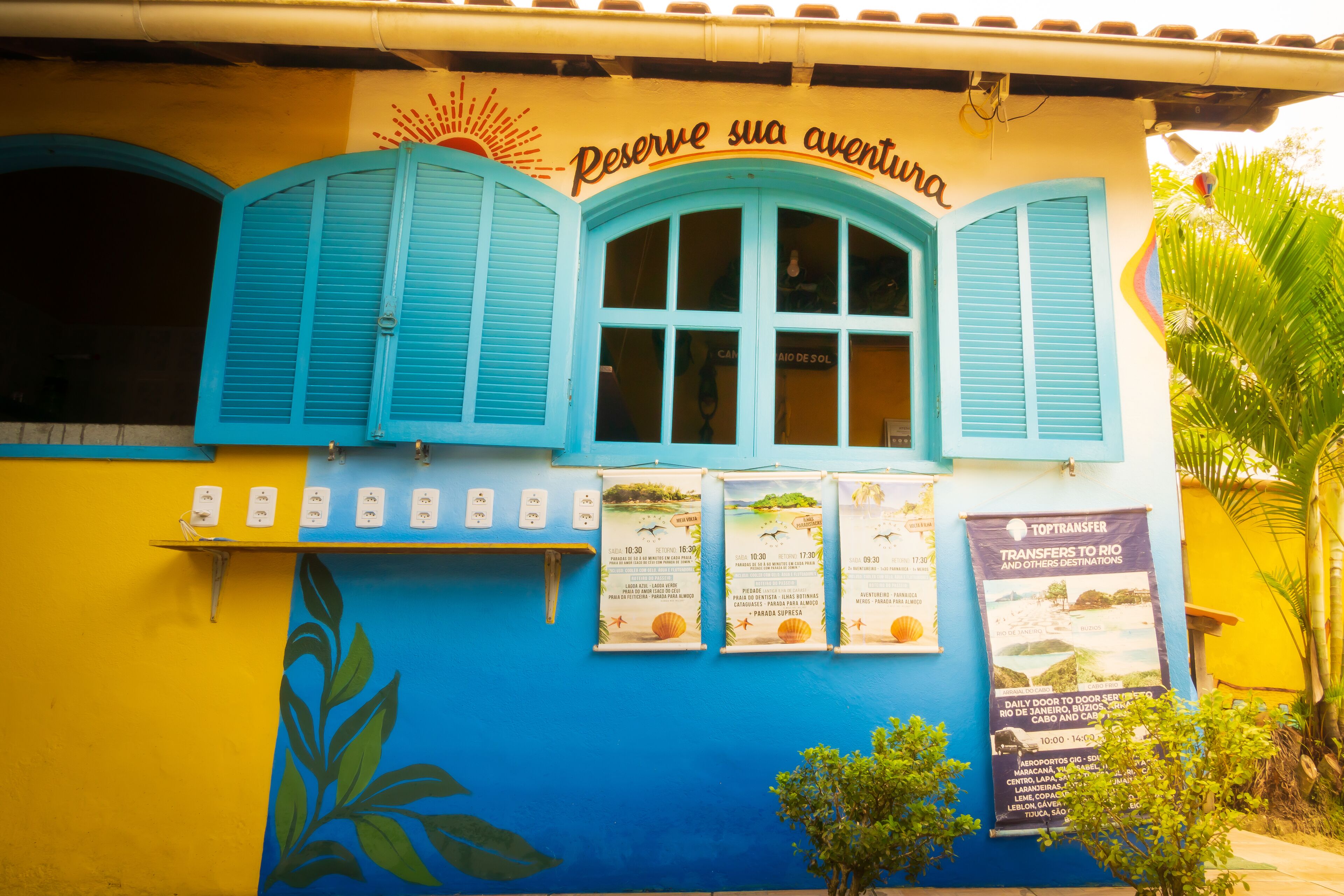 A colorful building with a sign reading "Reserve sua aventura".