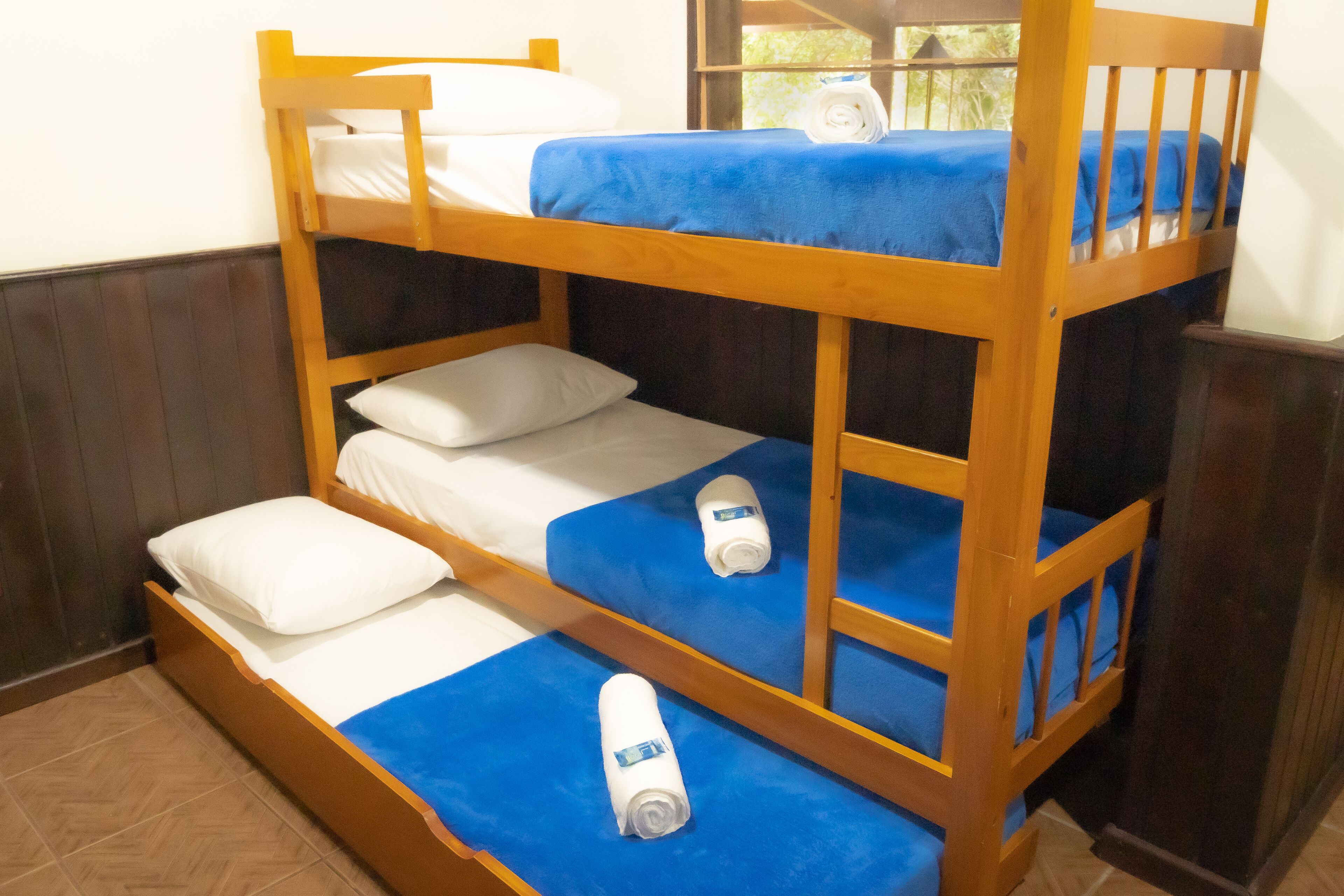 A bunk bed with blue bedding and white pillows.