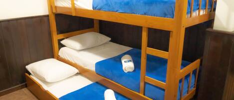 A bunk bed with blue bedding and white pillows.