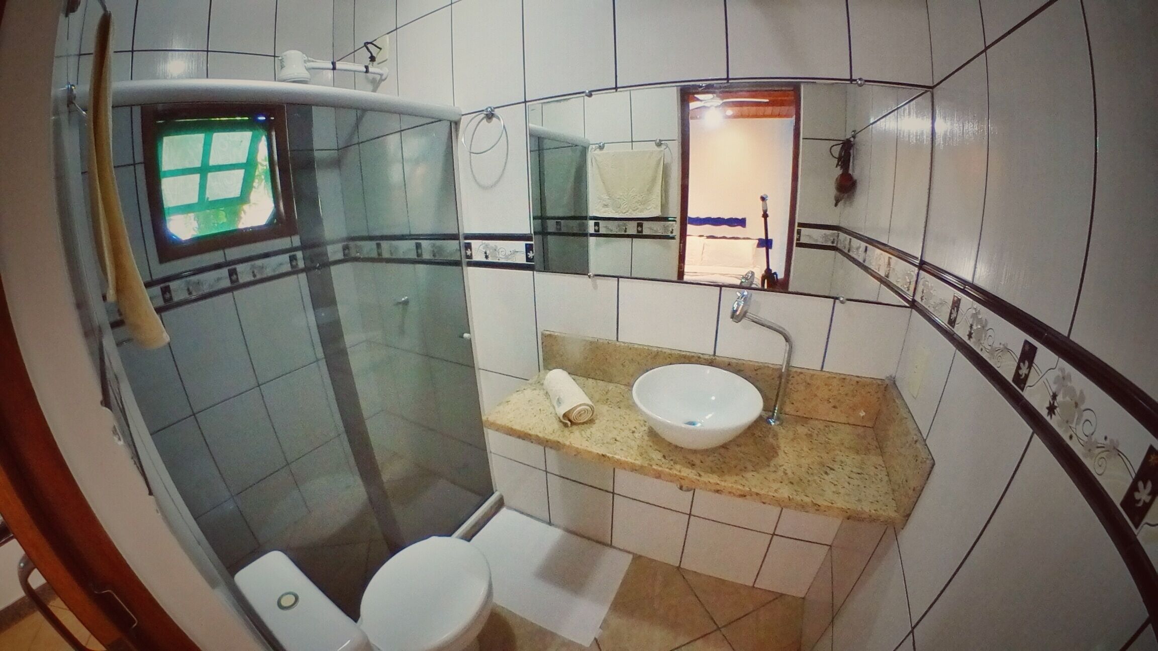 Une petite salle de bain avec des toilettes, un lavabo et une douche.