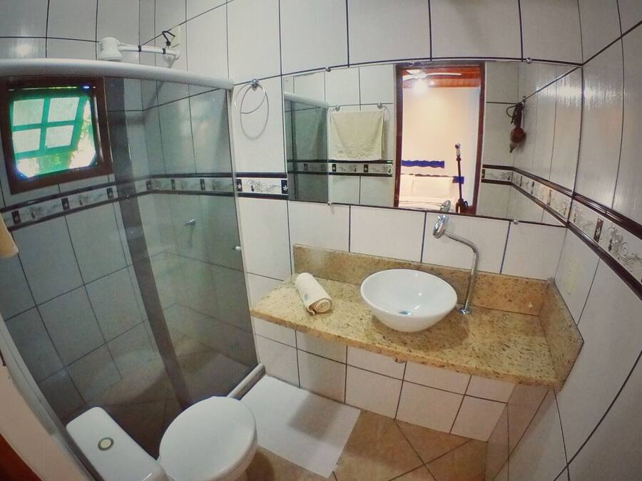 Une petite salle de bain avec des toilettes, un lavabo et une douche.
