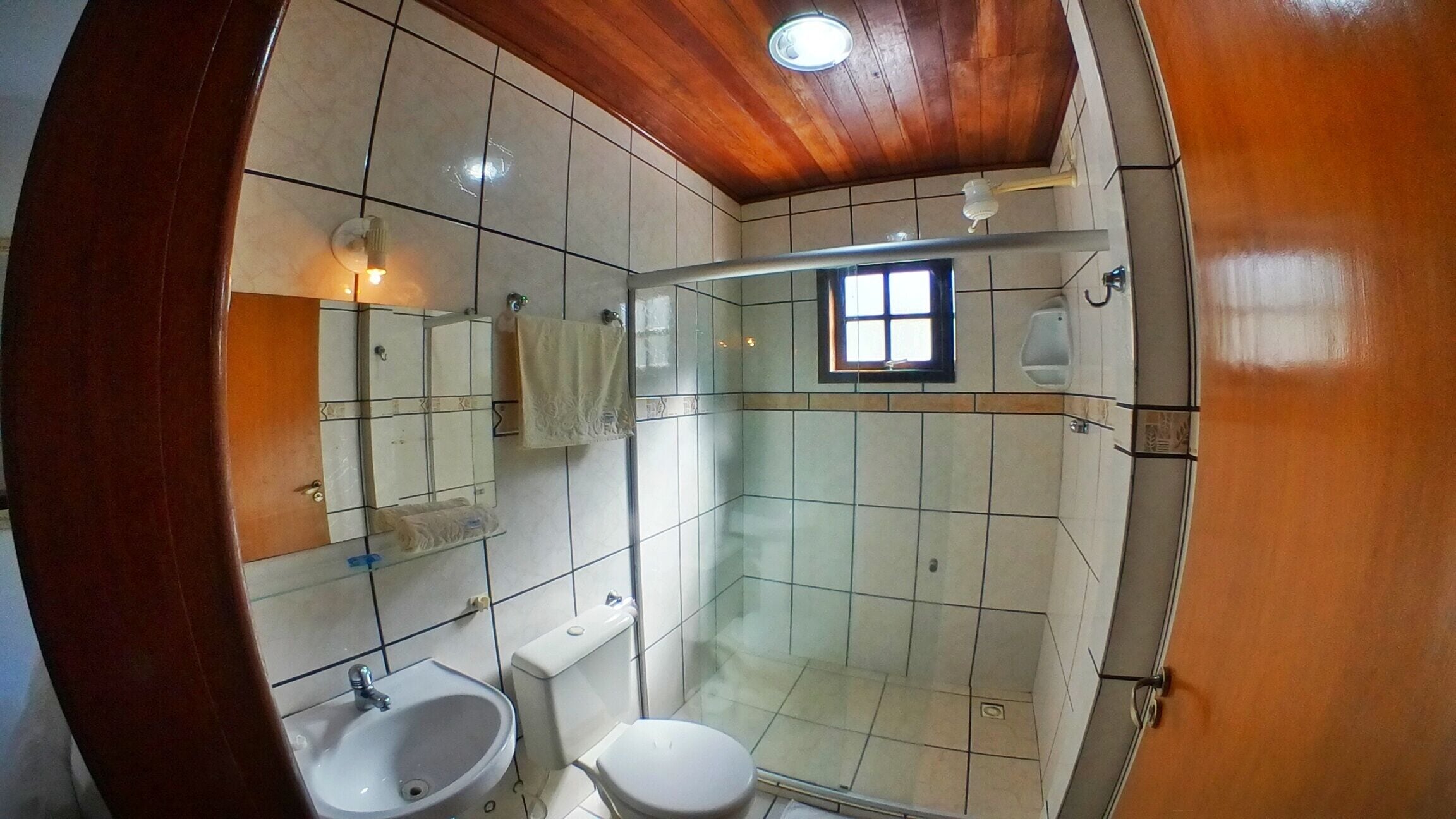 Kylpyhuone, jossa on suihku, wc, pesuallas ja peili.