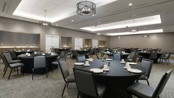 A conference room with multiple tables and chairs, equipped with nameplates and table settings.