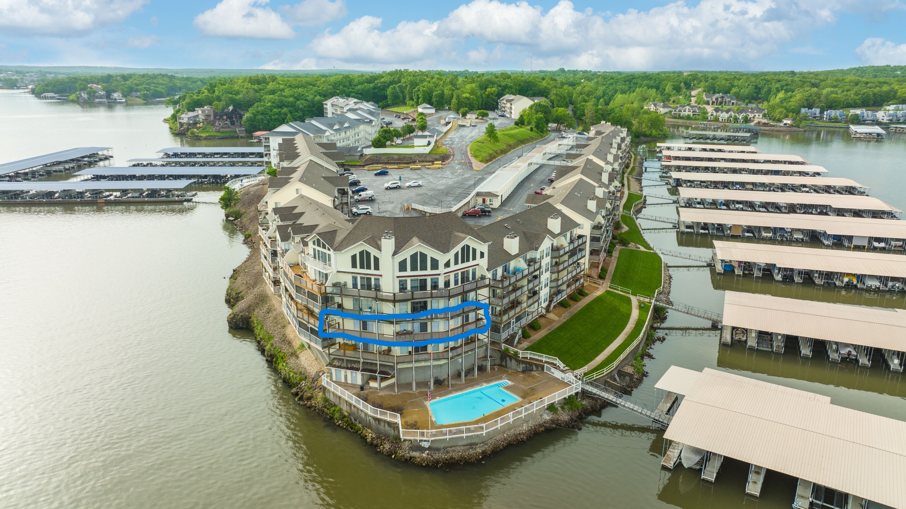 A waterfront hotel with a pool, multiple decks, and a dock area.