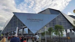 A modern Mercedes-Benz Stadium with a distinctive triangular roof and large glass facade. - Cozy Riverfront Retreat Close to City (Mableton)
