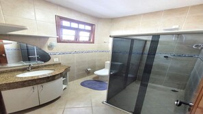 A bathroom with a sink, mirror, toilet, and glass shower enclosure. - Hotel Residencial Manaus (Manaus)