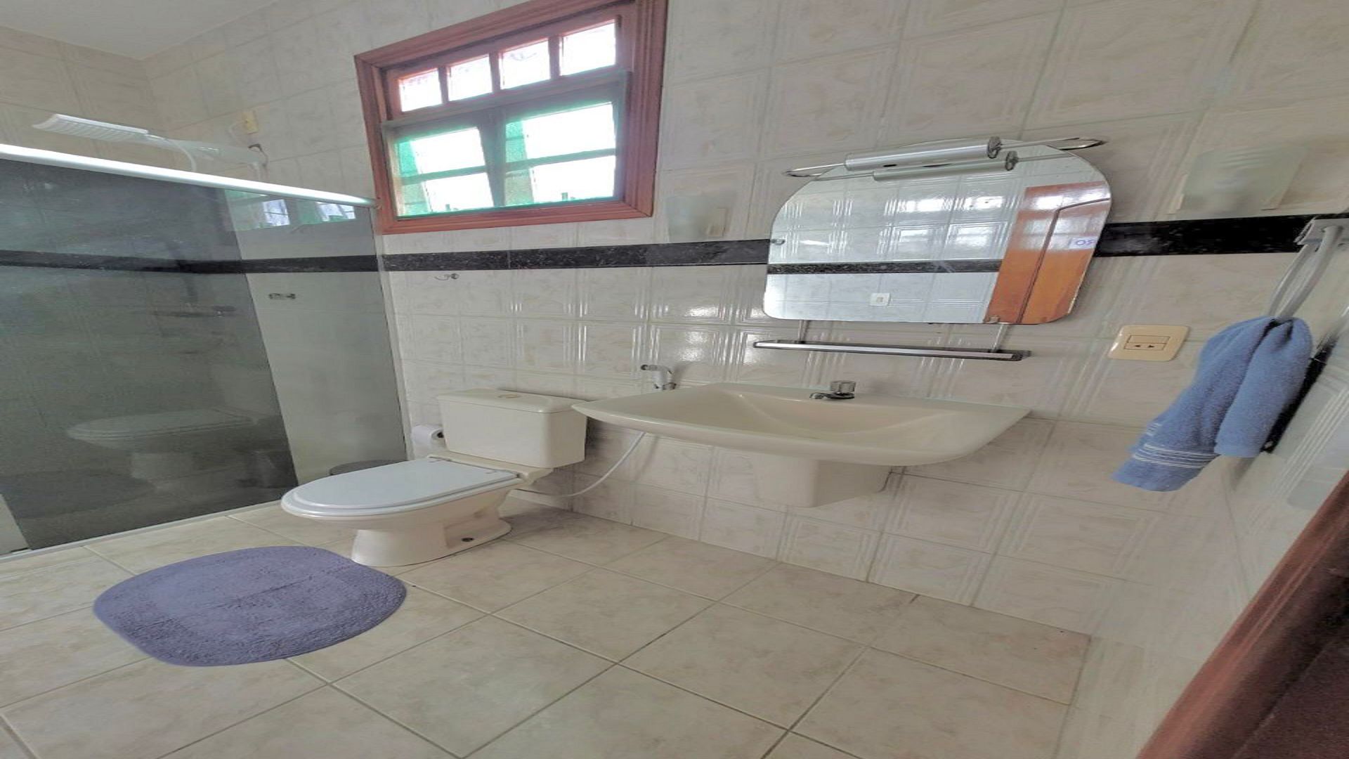 A bathroom with a toilet, sink, and shower.
