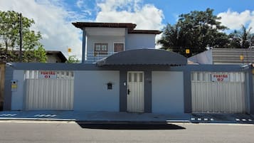 Un edificio con dos accesos portonados identificados como 'PORTÃO 01' y 'PORTÃO 02'.