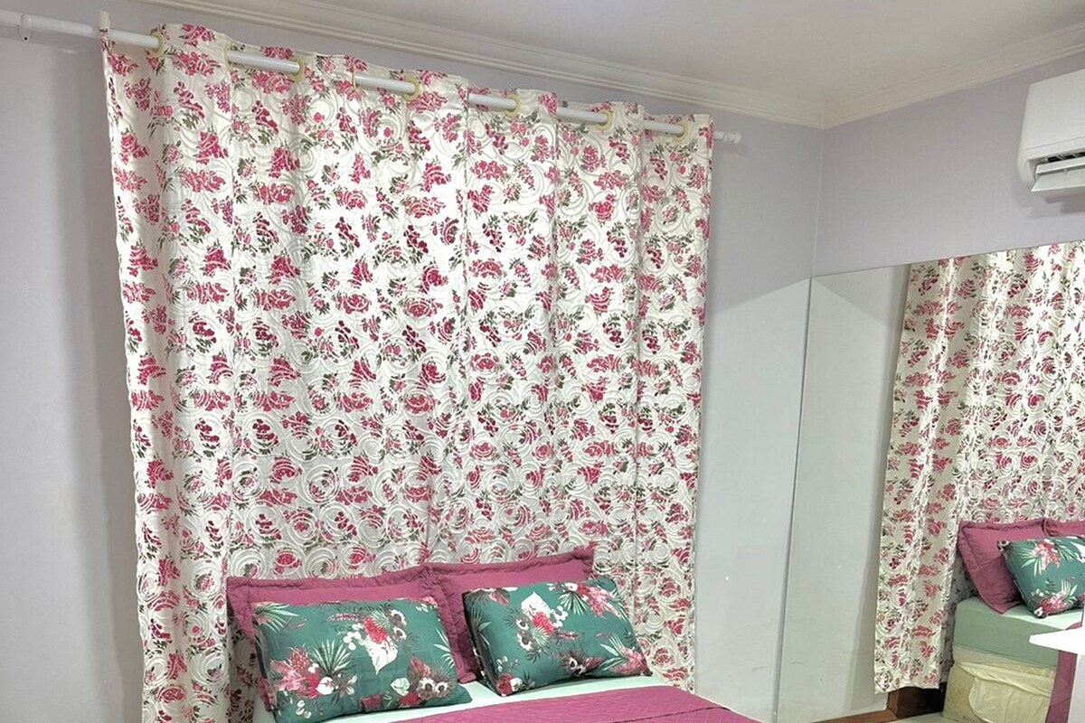 Une chambre à coucher avec un lit, une table de chevet, un miroir et un tapis moelleux.