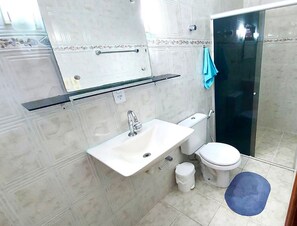 Une salle de bain avec un lavabo, des toilettes et un miroir.