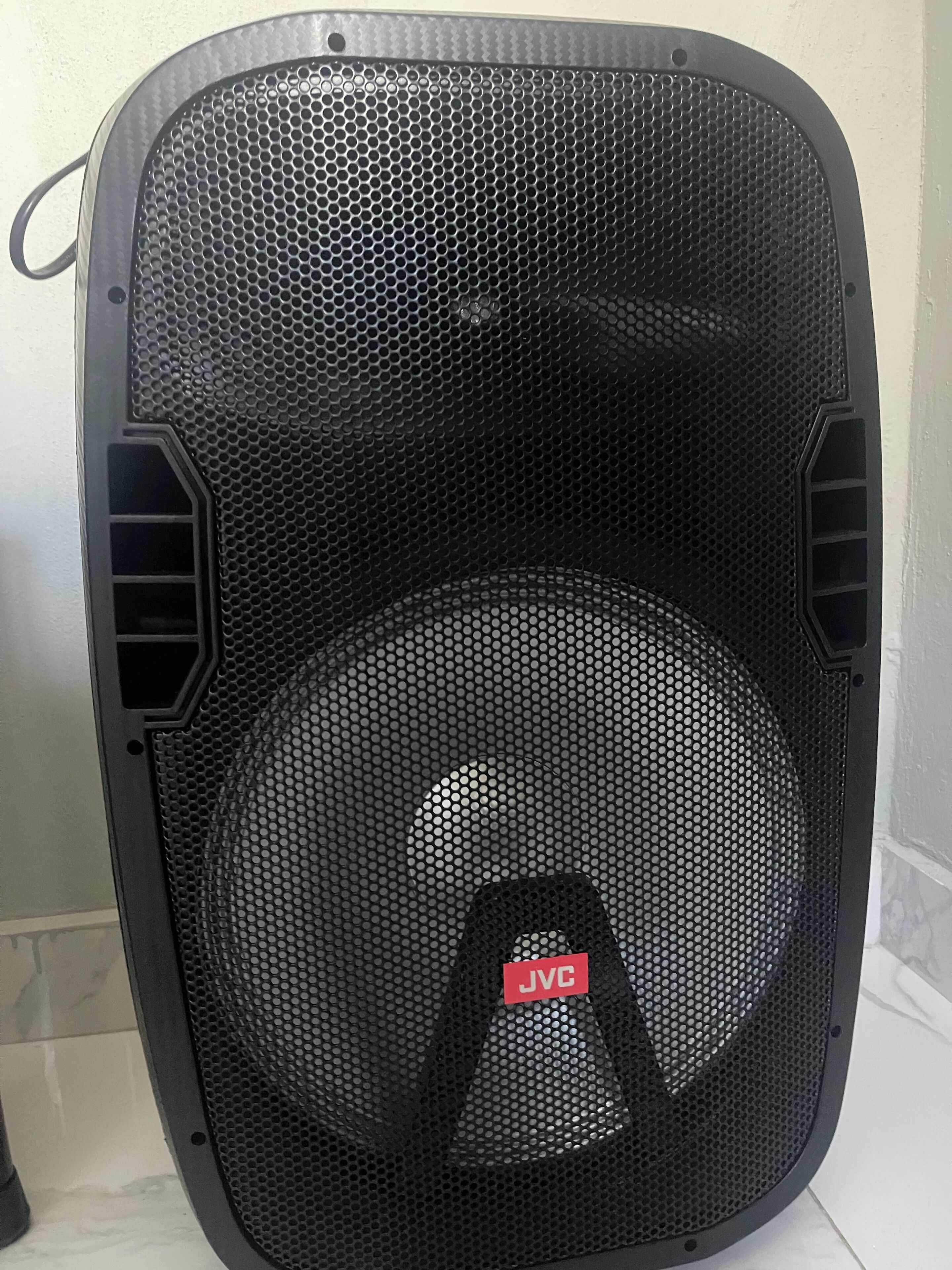 A black portable heater with a mesh front and a red label.