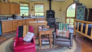 A cozy living room with a fireplace, wooden furniture, and a view of the outdoors. - Our Little Cabin, Life As It Should Be (Philipsburg)