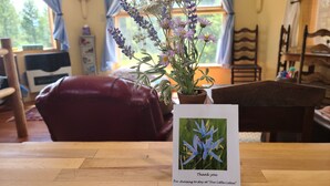 A wooden table with a thank you card featuring a blue flower. - Our Little Cabin, Life As It Should Be (Philipsburg)