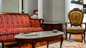 Un salon comprenant un canapé, une table basse, un fauteuil et une petite table sur laquelle se trouvent un livre et un objet décoratif.