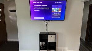 A television mounted on a wall displaying the Roku Guest Mode interface. - Walk to Lambeau, Resch, Expo, and Titletown (Green Bay)