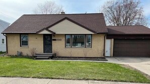 A single-story brick house with a gabled roof, a front door, and a garage. - Walk to Lambeau, Resch, Expo, and Titletown (Green Bay)