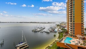 Un puerto deportivo con barcos amarrados, una piscina y un edificio alto con balcones.