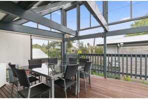Relax in this serene outdoor space with a glass-top table and comfortable seating.